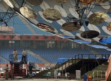 Workers prepare for the opening ceremony at the Jawaharlal Nehru Stadium, the main venue for the Commonwealth Games