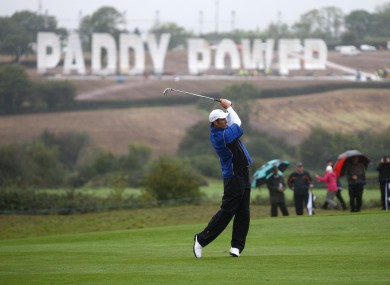 Europe's Ross Fisher tees off in a practice round yesterday - within clear view of the 270ft sign in a nearby field.