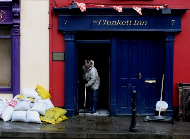 A Cork resident cleans up a pub after floods in the city last November.