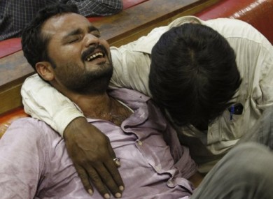 Relatives of shooting victims mourn outside a local hospital in Karachi, Pakistan, today.