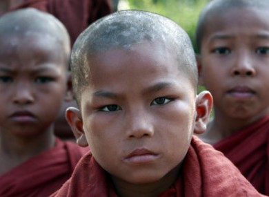 Young Myanmar Buddhist monks wait for food at a Thai border police base where Myanmar refugees have taken shelter in Mae Sot, Thailand, 9 November, 2010.
