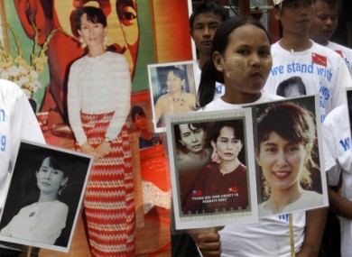 Members of Suu Kyi's National League for Democracy (NLD) hold her portraits as they gather at the party's headquarters today.
