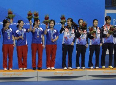 North Korean (left) and South Korean table tennis players celebrate after both teams won bronze medals in women's table tennis at the Asian Games. South Korea has reportedly said it would allow the North to hold some games in 2022.
