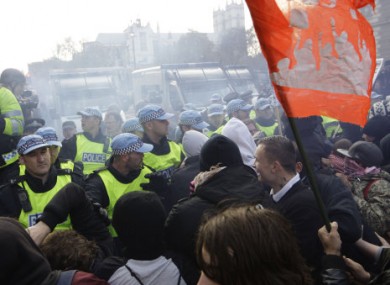 Protesters clash with police over tuition fee hikes at Whitehall, London, today.