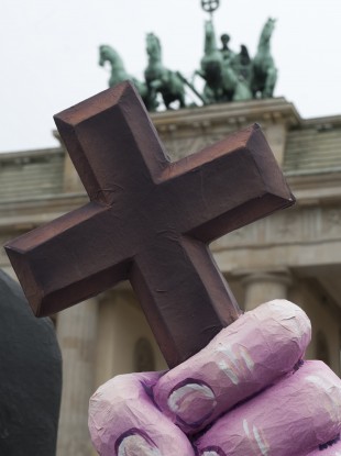 The hand of a character symbolising a nun holds a cross in front of the Brandenburg Gate during a demonstration against church abuse in Berlin earlier this year.