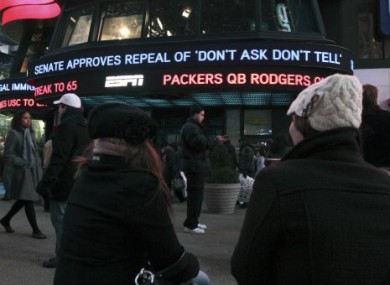 People stop to watch news of the DADT repeal displayed outside ABC Television in Times Square, New York.