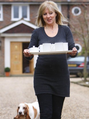 Julia Keys, wife of former Sky Sports presenter Richard Keys, brings a tray of tea to the media waiting outside her Surrey home.