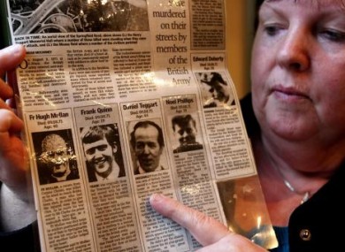 Alice Harper with a press cutting from August 1971 when 11 people, including her father Daniel Teggart, were killed in Ballymurphy, Belfast.