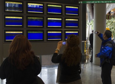 Passengers at Madrid Airpor take photographs of blank departures screens in December, following a wildcat strike by airport staff.