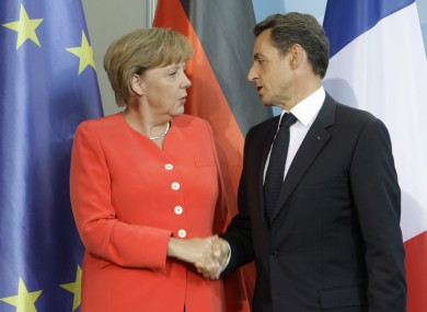 Merkel and Sarkozy shake hands after finding common ground at a meeting in Berlin today