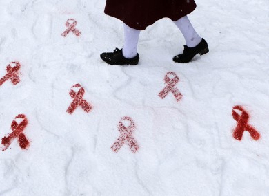 A schoolgirl walks past red ribbons stencilled in the snow by artist Will St Leger to mark World AIDS Day last December.