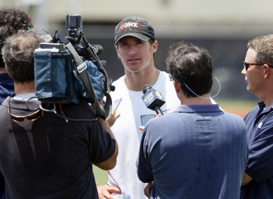 New Orleans Saints quarterback Drew Brees, center, speaks with reporters after a player-organized practice at Tulane University in New Orleans this morning.