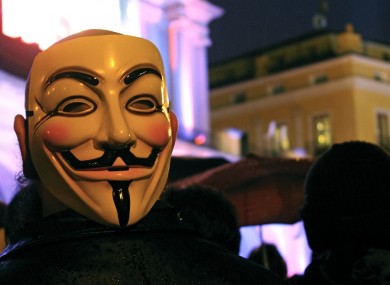 An Anonymous supporter wears the mask associated with the group