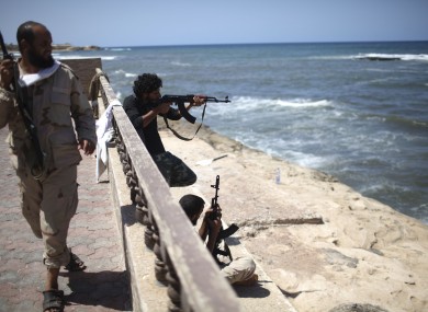 Rebel fighters fire on what is allegedly Gaddafi's beach house in Tripoli
