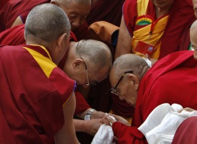 Tibetan spiritual leader the Dalai Lama, centre left, greets a monk as he arrives to attend an event in India last summer.