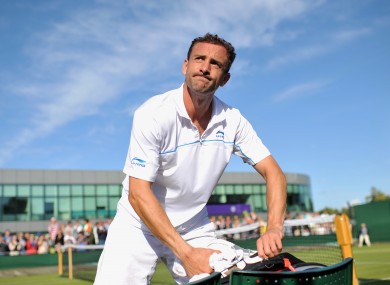 Niland packs away his rackets following his defeat against Adrian Mannarino at Wimbledon.