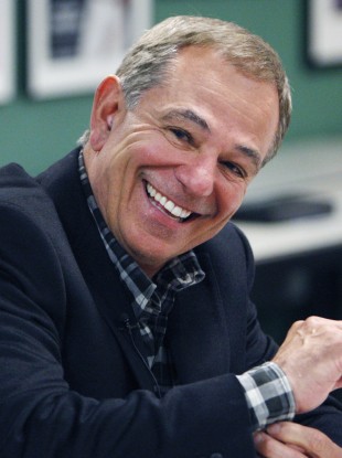 ESPN analyst Bobby Valentine smiling as he answers questions from reporters following his interview for the vacant Boston Red Sox manager position.