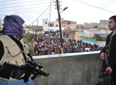 Syrian army defectors stand guard on a rooftop to secure an anti-Syrian regime protest in the Deir Baghlaba area in Homs province in January.