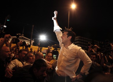 Left Coalition party leader Alexis Tsipras waves to supporters in central Athens after elections on Sunday, May 6, 2012
