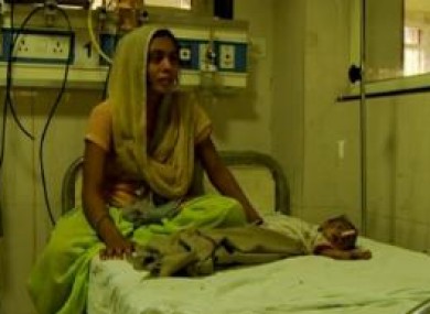 Baby Radhika recovering in hospital beside her mother.