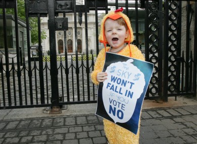 Toirleach O Murchu (3) dressed as a chicken, stands outside government buildings to demonstrate Sinn Féin's message that the
