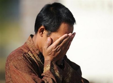 Imam Lahmuddin holds his hands over his face after a fire destroyed the Islamic Society of Joplin.