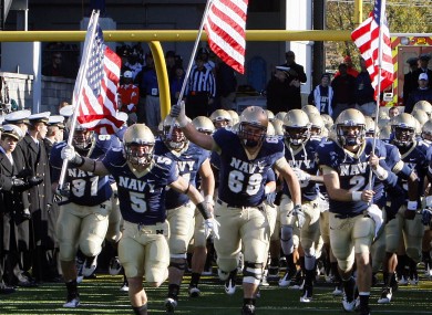 Members of the Navy team heading onto the field before a game last November. Their college football season opener is to take place in Dublin - but potential legal proceedings could put that under threat.