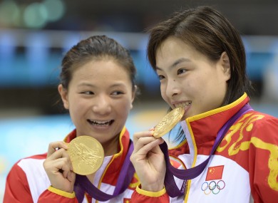 Gold medalists He Zi, left, and Wu Minxia, right, pose with their medals after the 3 Meter Synchronized Springboard final.