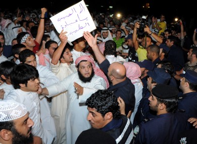 Kuwaiti citizens are contained by police while trying to reach the US embassy in Bayan, Kuwait City today.