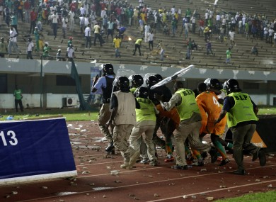 Kolo Toure (4) is among a group of Ivory coast players protected by riot police.