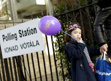 Sinead Yang Yang Glynn, aged four, passes a polling station in Ranelagh, Dublin with her mother Dan Dan Glynn yesterday.