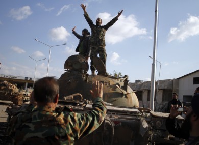 Syrian fighters celebrate victory on top of a tank after storming a military base in Aleppo