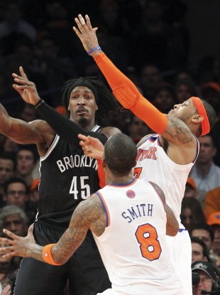 Brooklyn Nets' Gerald Wallace (45) fights for a loose ball against New York Knicks' J.R. Smith (8) and Carmelo Anthony during the first half of their game Wednesday night.