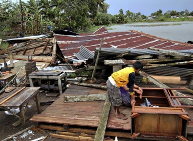 Residents assess their house which was damaged by Typhoon Bopha today.