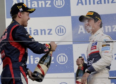 Formula 1 driver Sebastian Vettel, of Germany, sprays champagne into the face of Sauber's Kamui Kobayashi after the 2012 Japanese Grand Prix.