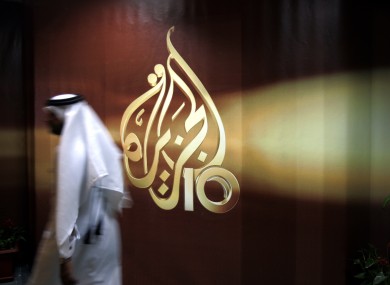File photo, employee passes by news channel logo of in Doha, Qatar.