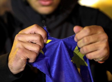 A protestor rips an European Union flag during a rally outside of the parliament in capital Nicosia.