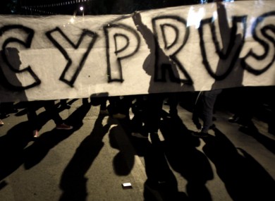 Protesters holding a banner during an anti- bailout rally outside of European Union house in capital Nicosia, Cyprus, yesterday.
