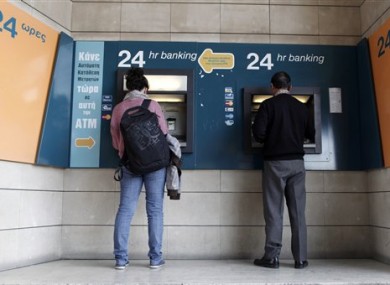 People use ATMs outside a closed branch of the Bank of Cyprus in capital Nicosia.
