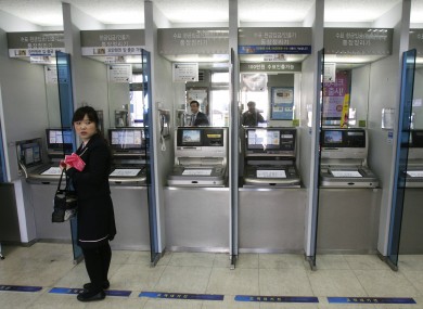 A customer stands in front of ATMs at a branch of Shinhan Bank in Seoul, after the bank's computer networks were paralysed in a suspected attack.