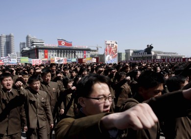 North Koreans punch the air during a rally in North Korea on 29 March in support of their Kim Jong Un's call to arms.