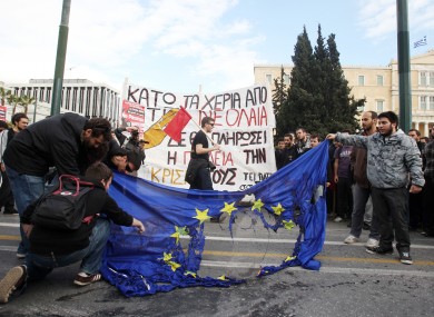 Young Greek people burn an EU flag late last month outside parliament in Athens at protests against education cuts.