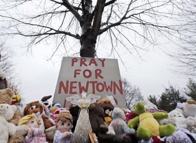 Stuffed animals and a sign calling for prayer sit at the base of a tree near the Newtown VIllage Cemetery in Newtown, Connecticut, after 26 people were shot to death at Sandy Hook Elementary School (file photo).