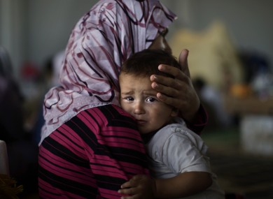 Amjad Al-Saleh, whose family fled to Turkey to escape the violence, is comforted by his mother.