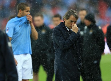 Manchester City manager Roberto Mancini stands on the pitch dejected after losing the FA Cup final.