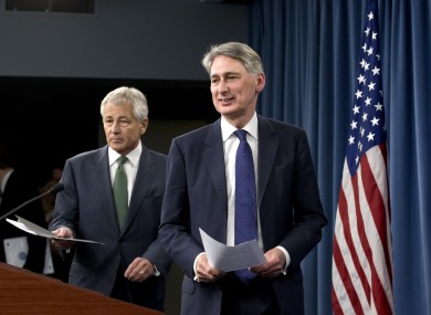Defense Secretary Chuck Hagel follows British Defense Secretary Philip Hammond for their joint news conference the Pentagon, Thursday, May 2, 2013, where they answered questions on Syria.