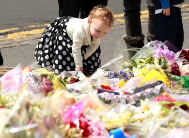 Two year old Ruby Kent from Hampton Court lays flowers outside the Royal Artillery Barracks, in Woolwich, east London close to the scene where Drummer Lee Rigby was murdered.