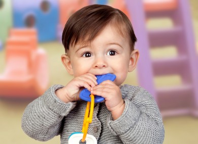 Adorable baby girl with a bite in her mouth