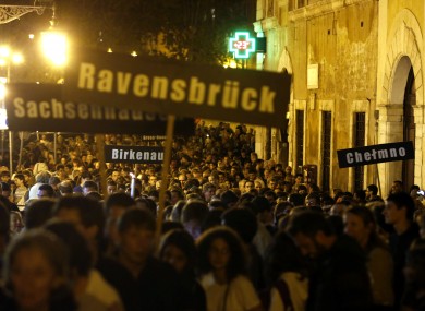 People hold up signs with names of Nazi concentration and death camps during a march marking the 70th anniversary of the roundup and deportation of Rome's Jews to concentration camps