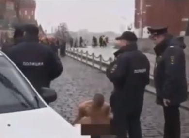 Police surround the artist who carried out the protest close to Lenin's mausoleum in Red Square yesterday